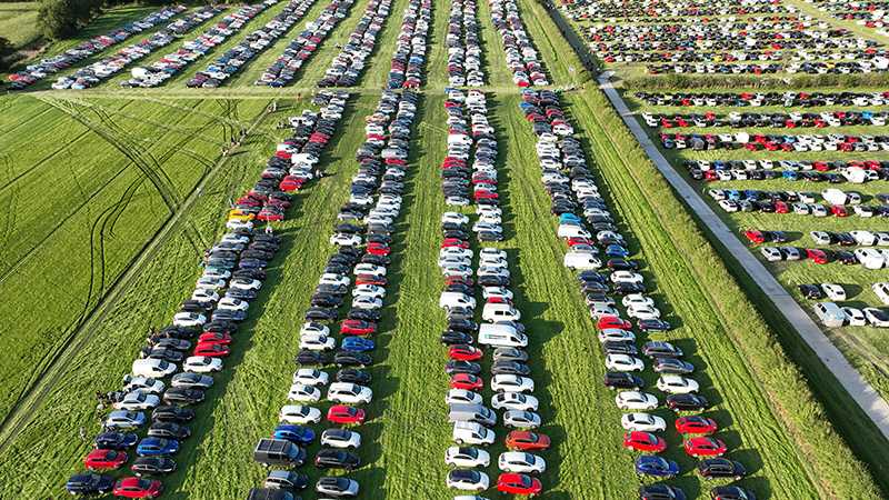 An aerial view of cars parked in a field at an event